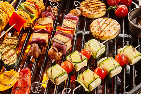 Plant-based burgers, tofu and vegetables on a barbecue grill