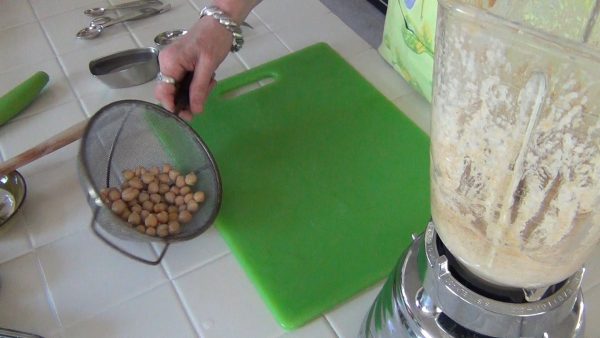 Add the beans in batches; add the water to reach the desired consistency.
