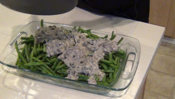 Arrange the green beans in a 9 x 13-inch baking dish (greased); spread the cream of mushroom soup over the beans.