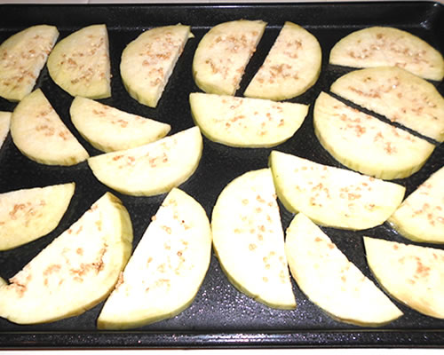Distribute the eggplant pieces on cookie sheets (greased); spray the eggplant pieces lightly with olive oil and bake at 350 degrees for 5 to 8 minutes -- turn over, spray the other side of the eggplant pieces with more olive oil, and bake for an additional 5 minutes.