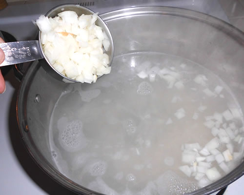 Bring the water to a boil, and add the rice and onion; boil until the rice is tender (about 15 minutes). Drain and reserve a portion of the liquid (1/2 cup for 6 servings).
