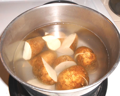 Boil the potatoes until slightly firm; allow to cool, remove skins and cut into cubes.
