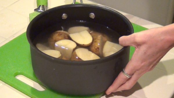 Boil the potatoes until tender (approximately 20 to 25 minutes); drain the water and remove part or all of the skins from the potatoes.