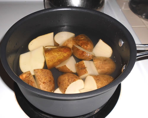 Boil the potatoes until slightly firm; drain, allow to cool, remove skins and cut into cubes.