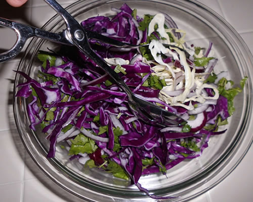 Mix together the cabbage, onion and cilantro in a large bowl.