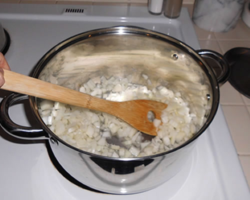 In a large pot, cook the onions in half of the water over high heat for 5 minutes; stir often until the water evaporates. Stir in the other half of the water and cook for 5 more minutes.