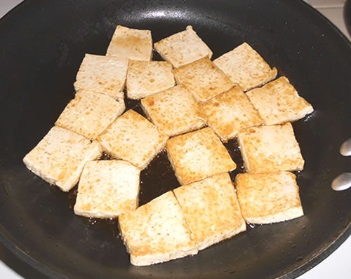 In a large pan, cook the tofu in the sesame oil until golden brown on both sides; drain on paper towels.