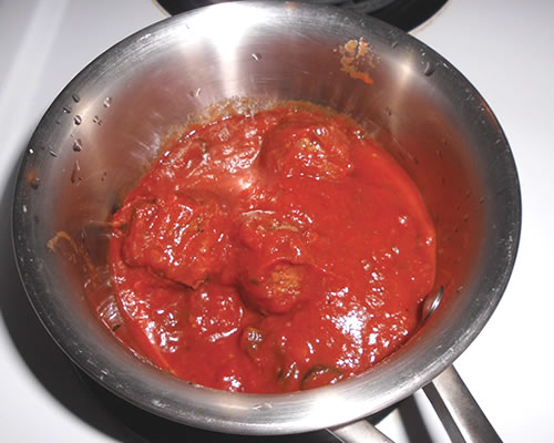 In a medium sauce pan, heat the pasta sauce and meatballs over medium heat until warmed through.