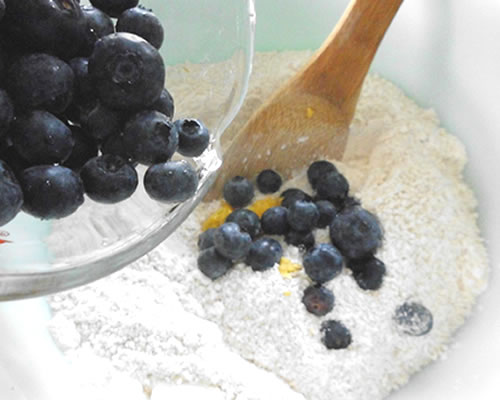 In a large bowl, mix together the flour, salt, baking powder, sugar, lemon zest and spices; add the blueberries and walnuts to the flour mixture.