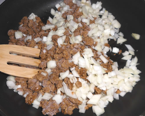 In a large pan, saute the meatless crumbles, garlic, and onion in the olive oil for 10 to 15 minutes over medium high heat; add the spices and water, and simmer for approximately 15 minutes.