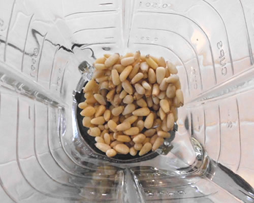 Blend (or process) the pine nuts until they are finely chopped.