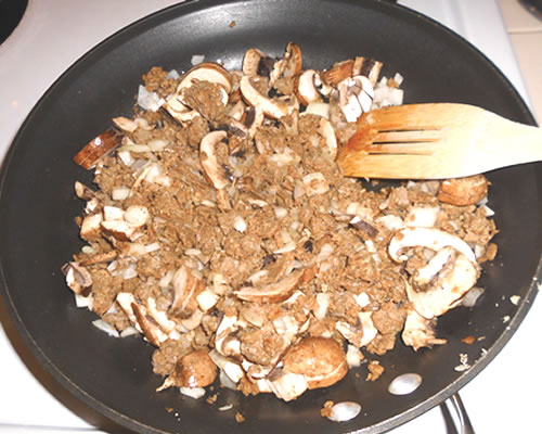 In a large skillet, combine the meatless crumbles, onion, garlic, spices, and mushrooms in the melted butter; cook over medium heat until the vegetables are tender, approximately 5 to 10 minutes.