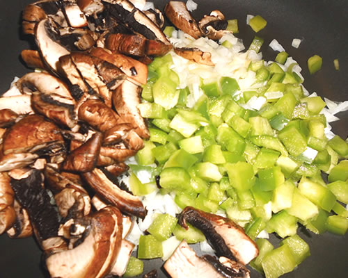 In a large pan, saute the onion, bell pepper, mushrooms and garlic in the oil over medium high heat for 10 minutes or until slightly tender.