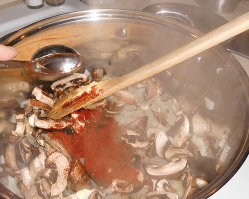 Add the mushrooms and spices to the onions; lower the heat, cover and cook for 5 minutes, stirring frequently.