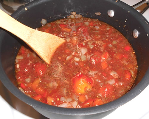 Add the remaining sauce ingredients, bring to a boil, cover and simmer for at least 20 minutes; uncover and cook for an additional 10 minutes, stirring occasionally. Spoon enough of the sauce into a greased baking pan to coat the bottom of the pan.