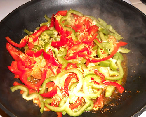 In a large pan, saute the cutlets in the oil over medium high heat for approximately 3 minutes; turn over and top with the peppers, lemon zest and juice. Cover and simmer for approximately 30 minutes.