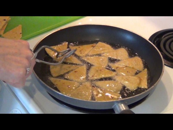 In a large pan, heat the oil over medium high heat; add the tortilla wedges one batch at a time and cook until lightly golden on each side.