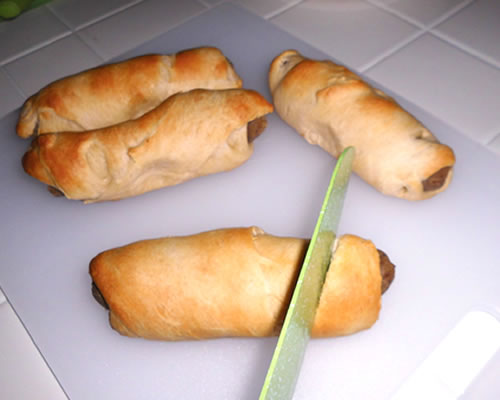 Bake the covered hot dogs on a cookie sheet at 350 degrees for 6 to 10 minutes or until the dough is lightly browned. Slightly cool and cut the hot dogs into one-inch pieces; serve with the mustard.
