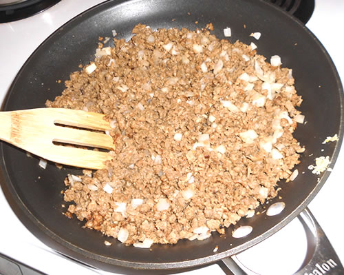 In a large pan, heat the olive oil over medium high heat; saute the hamburger crumbles, onion and garlic until cooked, approximately 15 minutes. Add the chili powder, cumin, black pepper and water, and cook on medium low heat for another 10 to 15 minutes.