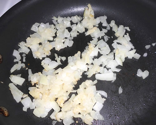 In a medium pan, saute the onion and garlic in the oil over medium heat until tender.