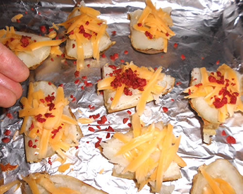 Arrange the potato wedges onto baking sheets; sprinkle the bacon bits and cheddar cheese onto the wedges, and broil for 5 minutes or until the cheese is melted.