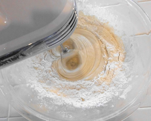 In a large bowl, cream together the buttery spread and sugar until light and fluffy; add the egg replacer, milk, vanilla and lemon extract. Mix the dry ingredients into the buttery spread and sugar mixture; chill covered for at least two hours.
