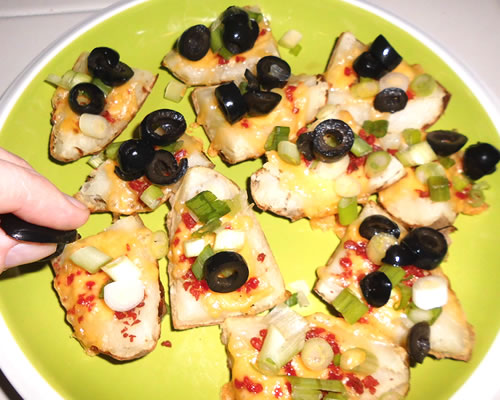 Top the wedges with the green onions and black olives; serve with the sour cream.