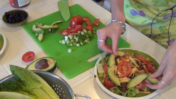 Add the remaining salad ingredients; place the tortilla chips around the side of the salad.