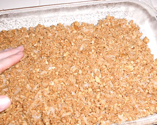 Press the mixture into an 8 x 8-inch baking pan (greased) until smooth and firm; bake at 350 degrees for 15 to 20 minutes or until lightly browned on the bottom. Cool.