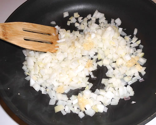 In a large pan, saute the onion and garlic in the oil for approximately 5 minutes or until tender.