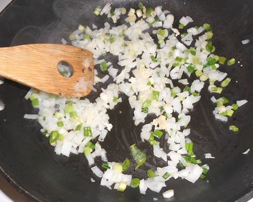 Add the remaining olive oil to the pan and saute the green onions, yellow onions, garlic, and basil for 2 minutes; add the rice and stir for approximately 5 minutes until the rice is lightly browned / golden.