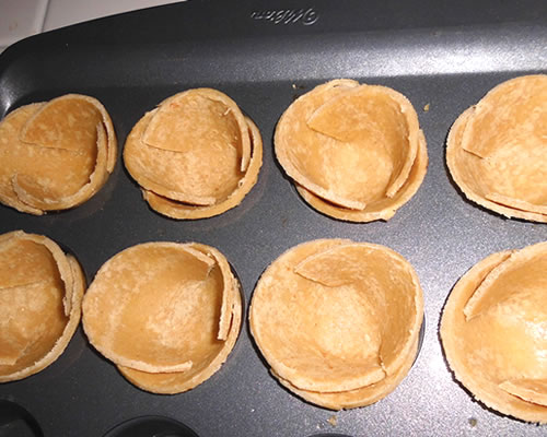 Press the tortilla rounds into a small cupcake tin (greased) and bake at 375 degrees for 5 minutes or until very lightly browned / set.
