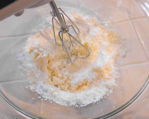In a medium bowl, blend the sugar and buttery spread; add the milk and almond extract until well blended.