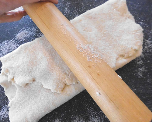 Roll the dough onto a lightly sugared board into a rectangle that is 8 x 16 inches; fold ends toward the center, overlapping. Sprinkle with the sugar; roll again to the same size and repeat two more times, ending in the rectangle.