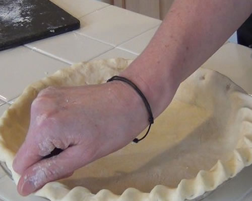 Transfer the rolled pie crust into the pie plate; press firmly against the bottom and sides of the plate, and flute the crust into the desired design. Fill the crust and bake according to the pie recipe instructions.