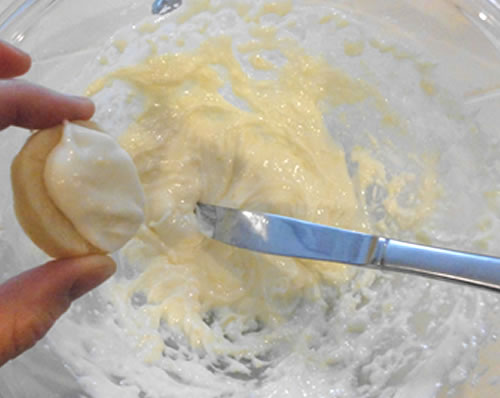 Using a table knife, top the cooled lemon cookies with the frosting.