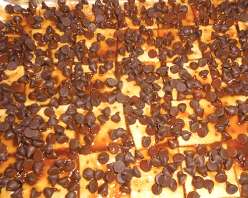 Sprinkle the chocolate chips over the top of the cracker / toffee layer; once the chocolate has softened after a few minutes, spread the chocolate.