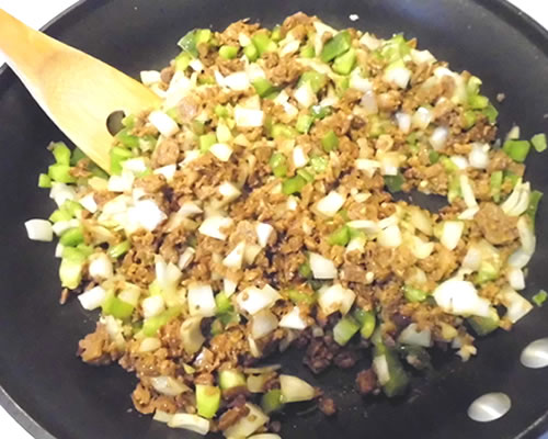 In a large pan, saute the crumbles, onion, bell pepper, and garlic in the oil over medium heat until the onions are tender, approximately 20 minutes. Add the chili powder, cumin, black pepper, and water; cook over low heat for 10 minutes.