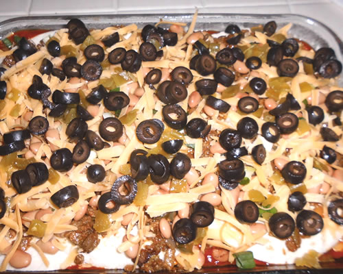 Repeat twice, and sprinkle the top with the black olives. Cover and bake at 375 degrees for approximately 60 minutes or until heated through, the cheese is melted and the sauce is bubbly. 