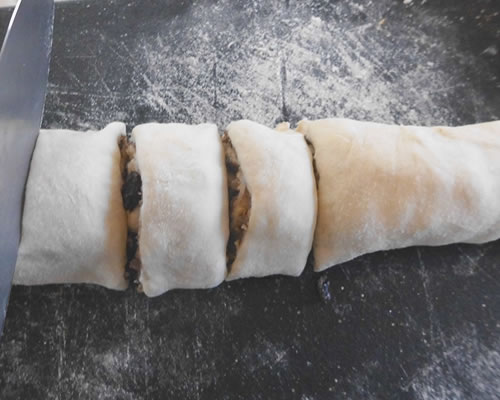 On a lightly floured board or other surface, roll half of the dough into a large rectangle (approximately 15 x 9 inches). Brush on the buttery spread. Sprinkle the cinnamon and sugar mixture over the rolled out dough. Roll the 15-inch side of the dough up tightly. Cut into nine 1-1/2 inch slices. Repeat with the other half of the dough. Place the rolls in two greased square pan slightly apart (or greased large muffin tins); allow the rolls to rise another 40 minutes. Bake at 375 degrees for 25 to 30 minutes or until golden brown.